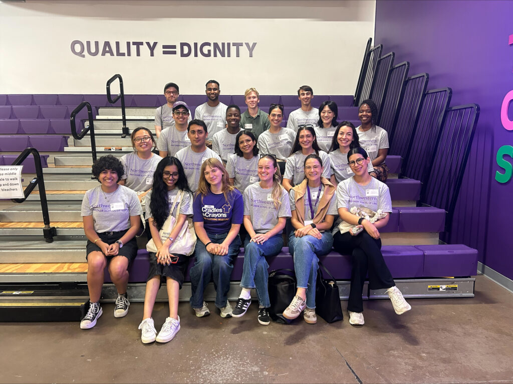 Northwestern Pritzker Law students sitting on the bleachers at Cradles to Crayons